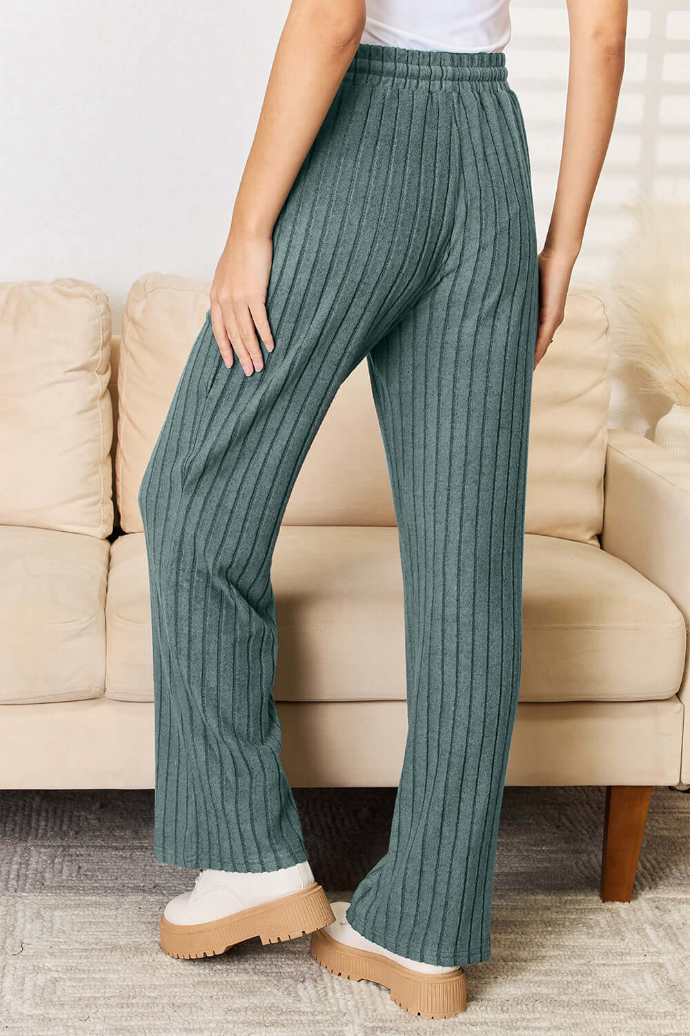 Back view of ribbed straight pants in teal color, showcasing drawstring waistband and relaxed fit.